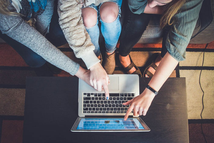 group of friends use a laptop computer