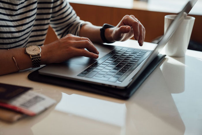 woman types on a laptop