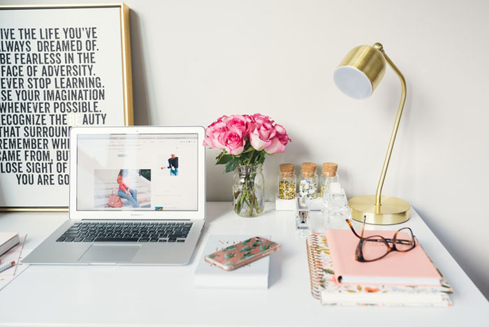 laptop and spiral notebooks on a desk